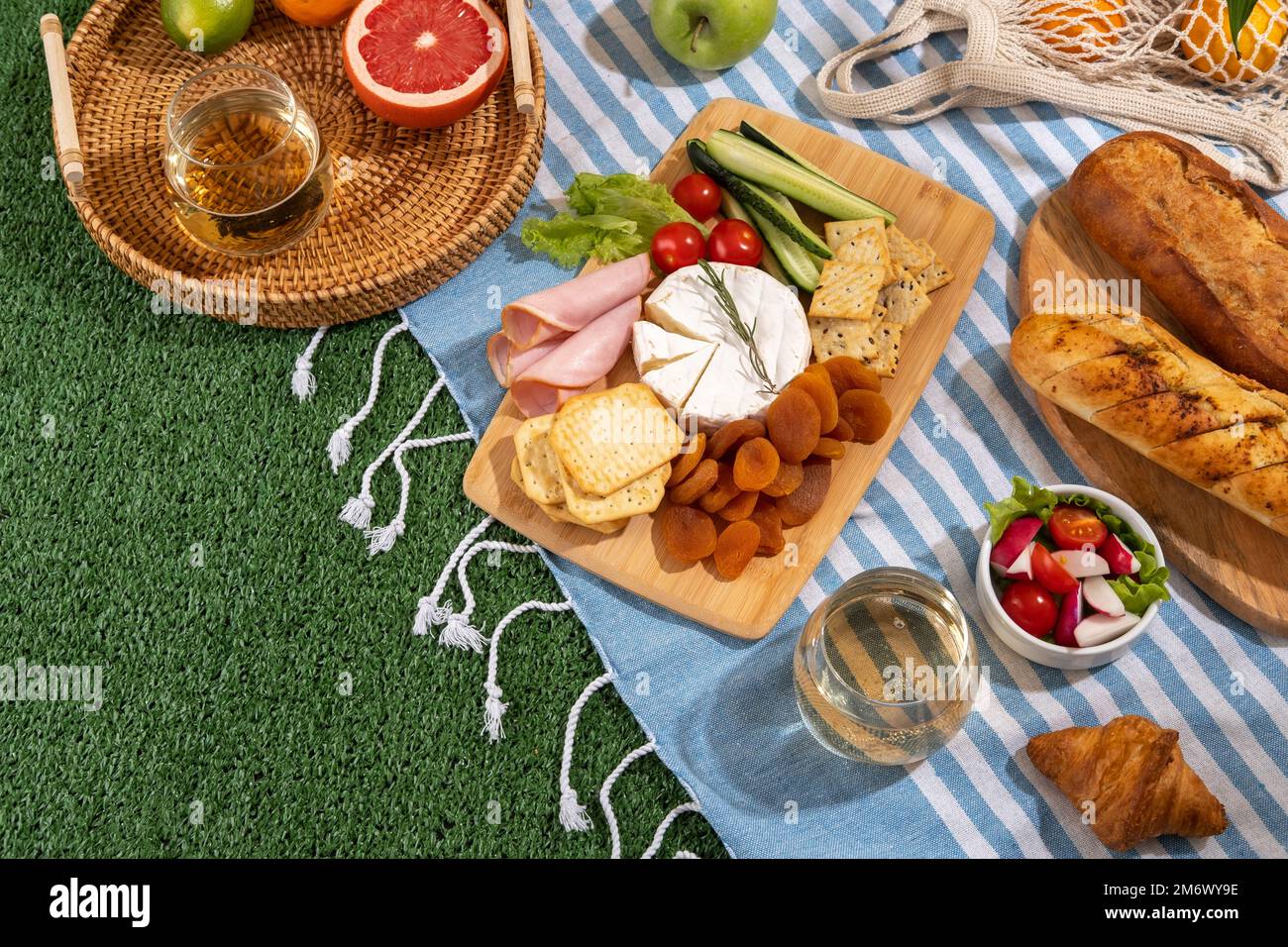 Coperta da picnic con salumi, cibo sano e vino nel parco in erba nelle giornate di sole. Foto Stock