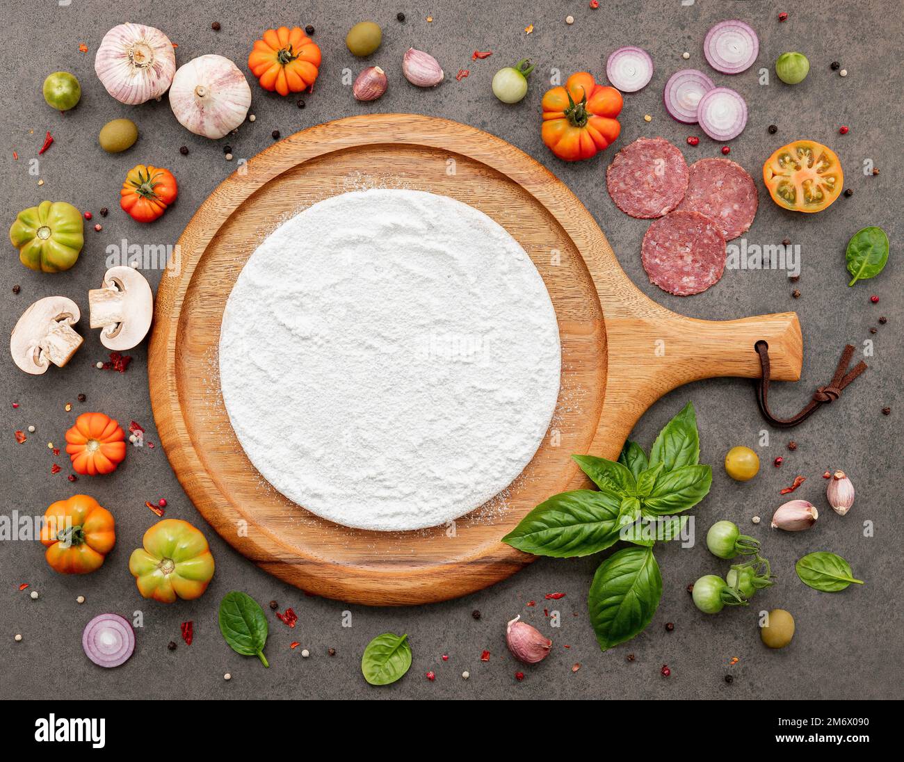 Gli ingredienti per la pizza fatta in casa sono su sfondo di pietra scura. Foto Stock