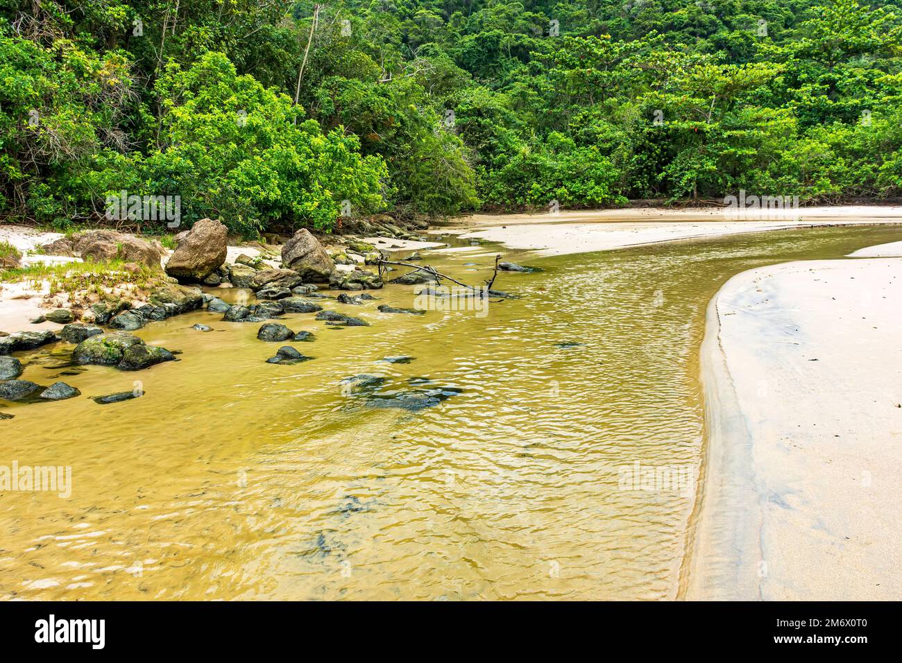 Fiume con acqua che scorre sulla spiaggia di sabbia verso il mare a Trindade Foto Stock