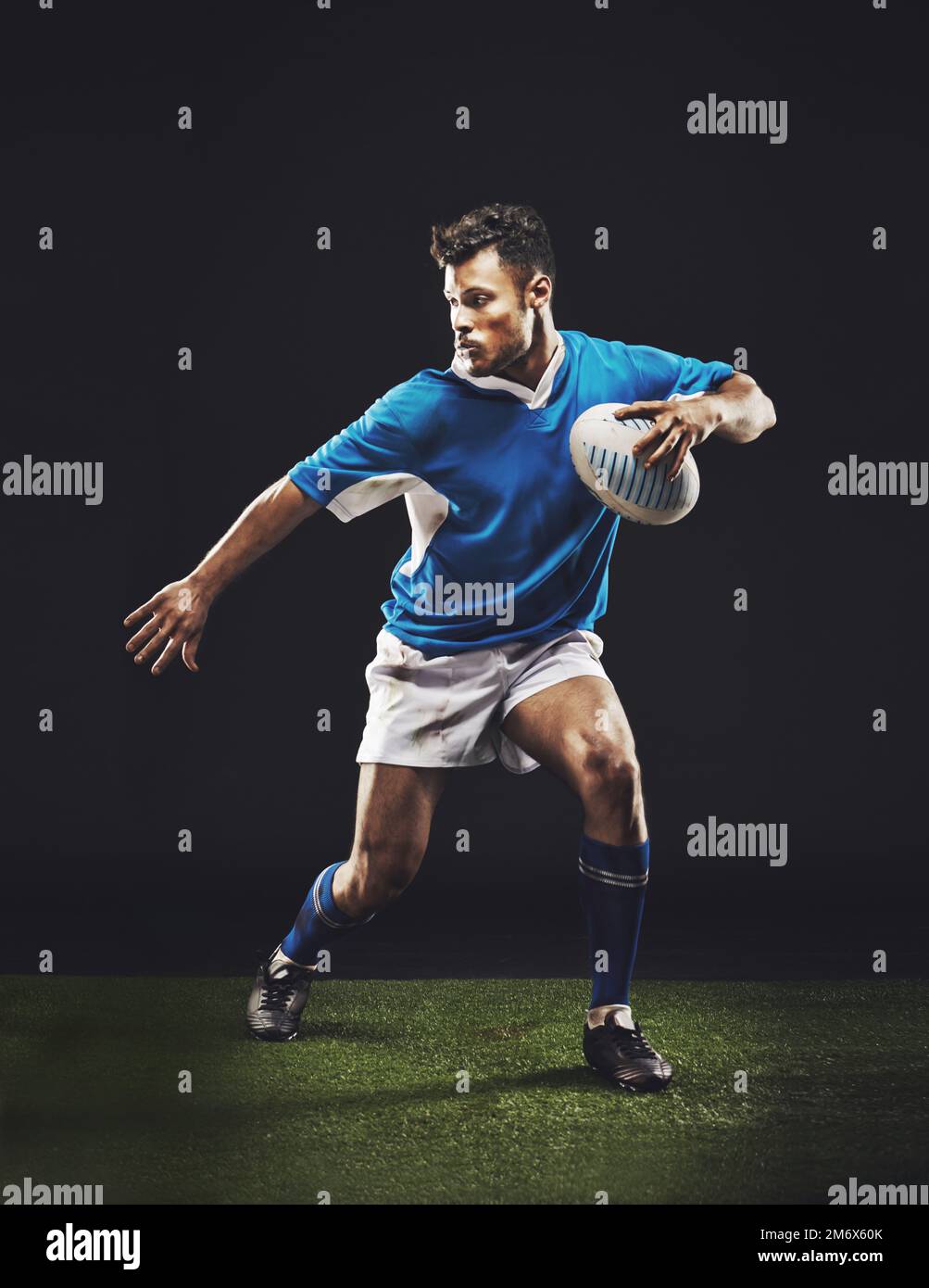 HES che dà tutto. Ripresa in studio di un giovane giocatore di rugby sul campo. Foto Stock