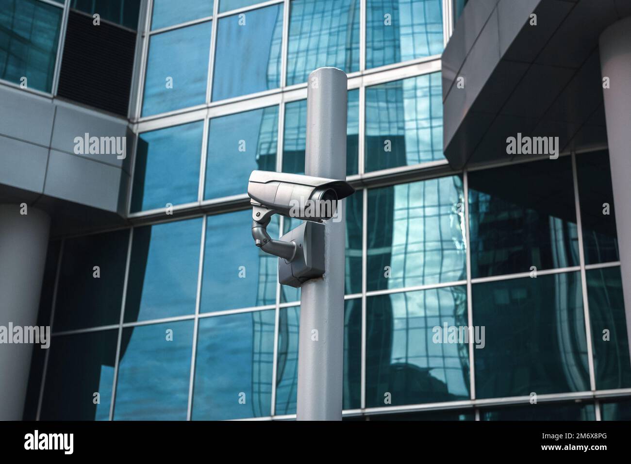 Telecamera di sorveglianza esterna contro la facciata dell'edificio in vetro Foto Stock