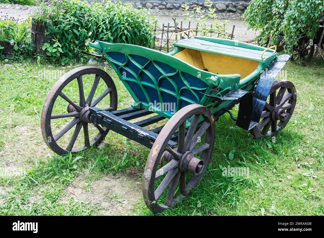 Un vecchio carrello per viaggi in un cablaggio con un cavallo sta sull'erba Foto Stock