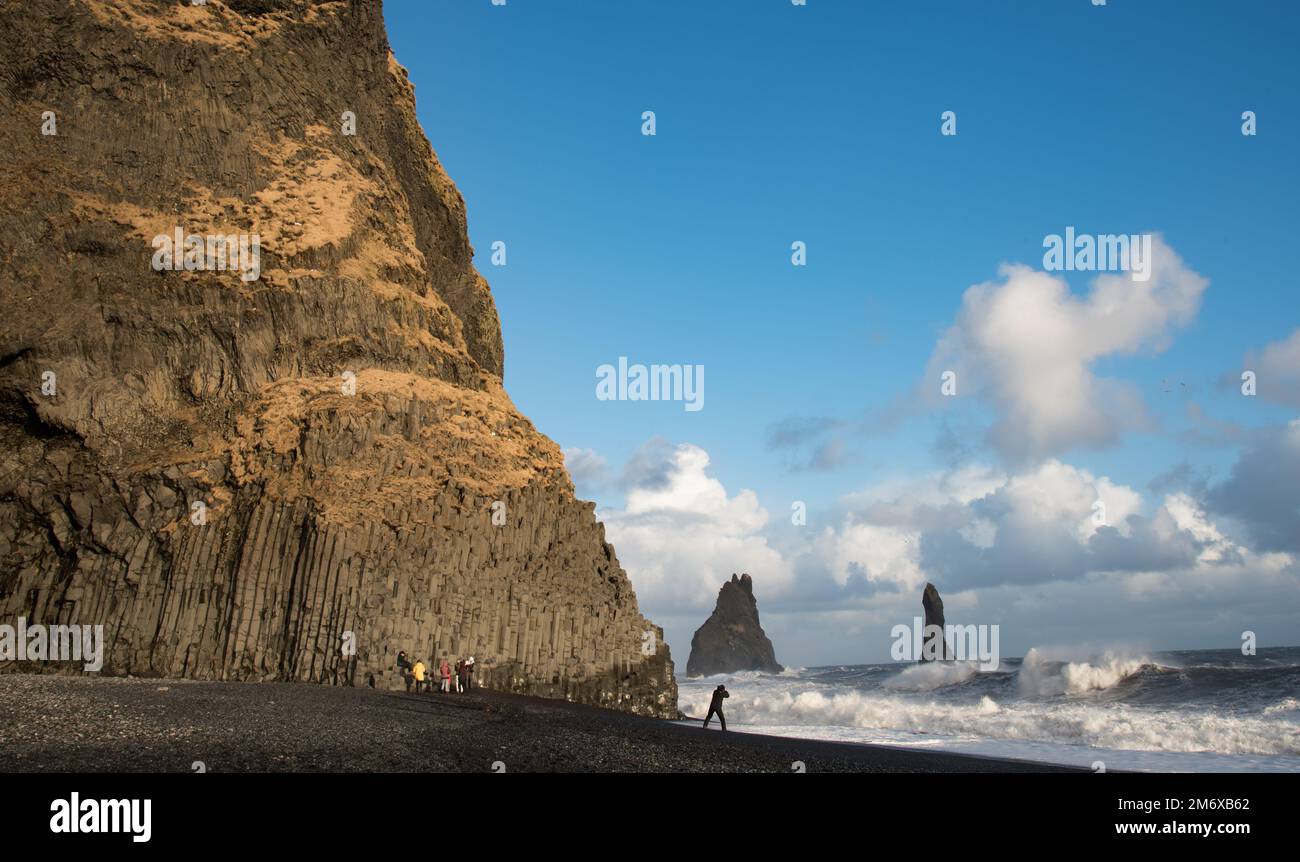 La gente visita alla spiaggia di sabbia nera di reynisfjara in Vik i Mydral sud dell'Islanda. Oceano Atlantico pericolose onde ventose Foto Stock