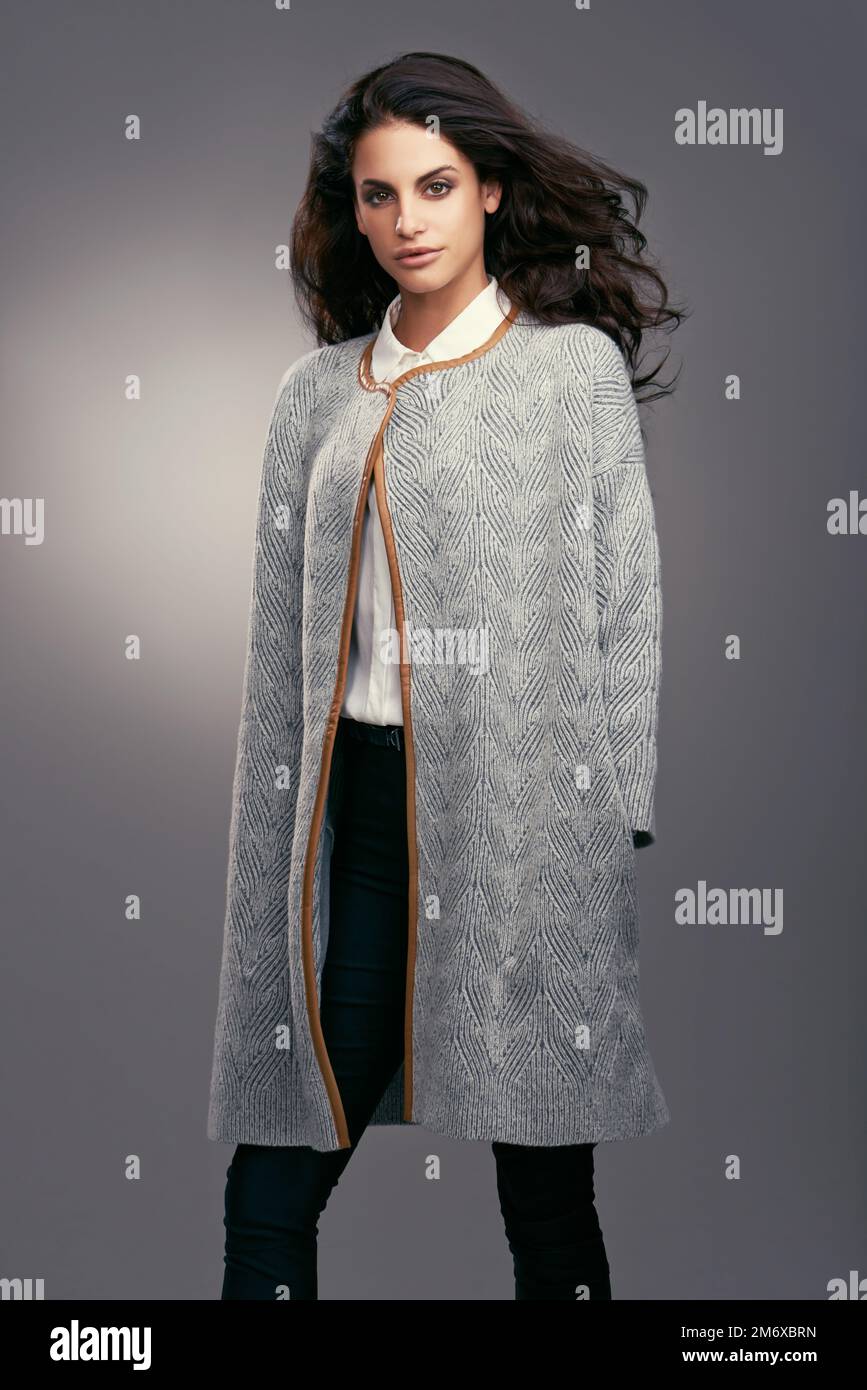 Couture invernale. Studio di una giovane donna vestita elegantemente su uno sfondo grigio. Foto Stock
