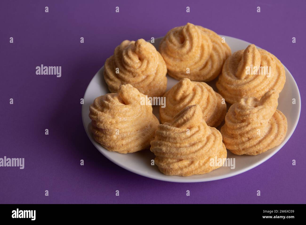 foto torte fresche giacenti su un piatto su uno sfondo viola Foto Stock