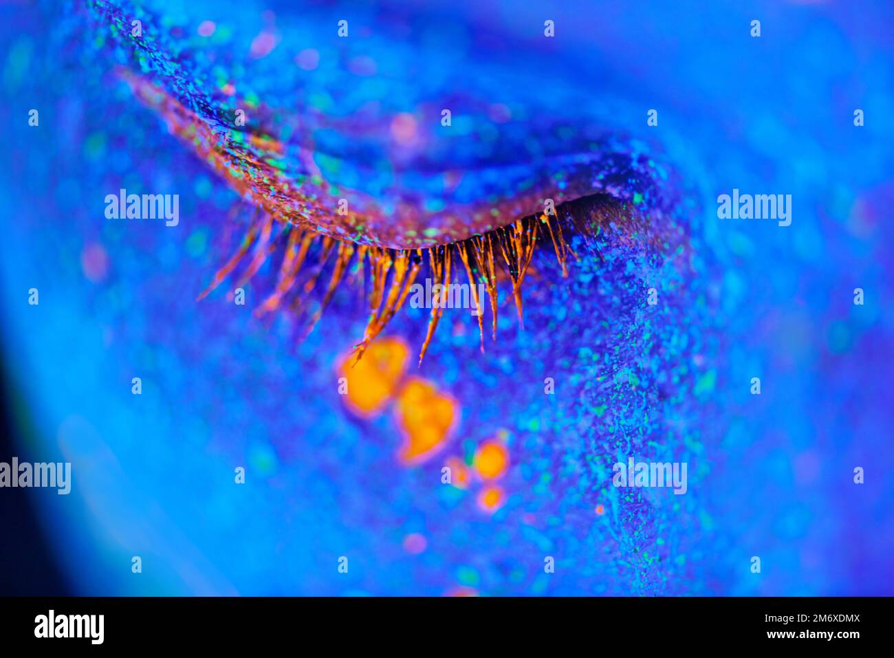 Bellezza da sogno. una giovane donna che posa con vernice al neon sul suo viso. Foto Stock