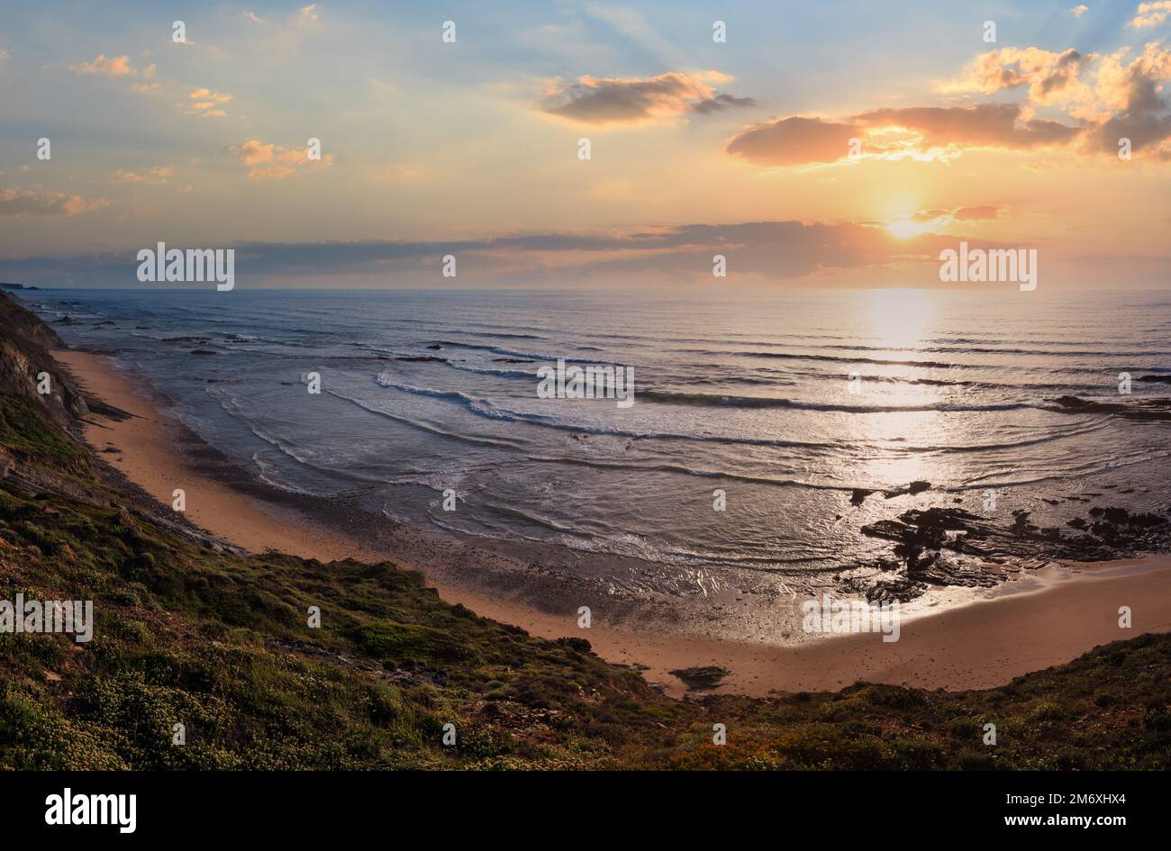 Serata estiva vista oceano sulla Spiaggia Carriagem a bassa marea (Aljezur, Algarve, Portogallo). Foto Stock