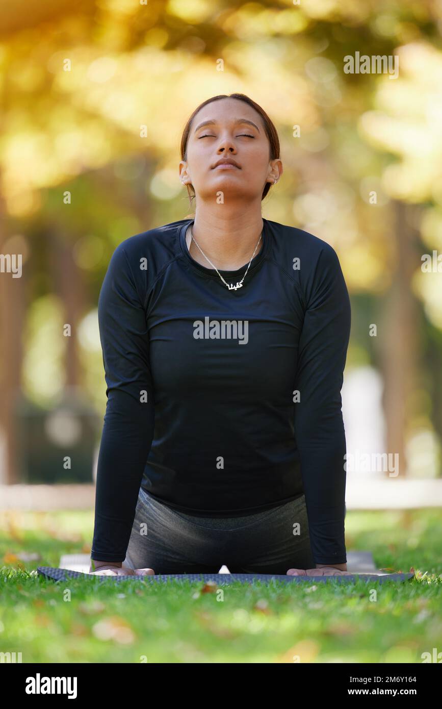 Yoga, cobra stretching e donna al parco per la salute, il benessere e la flessibilità. Zen chakra, pilates posa e femmina con occhi chiusi allenamento Foto Stock