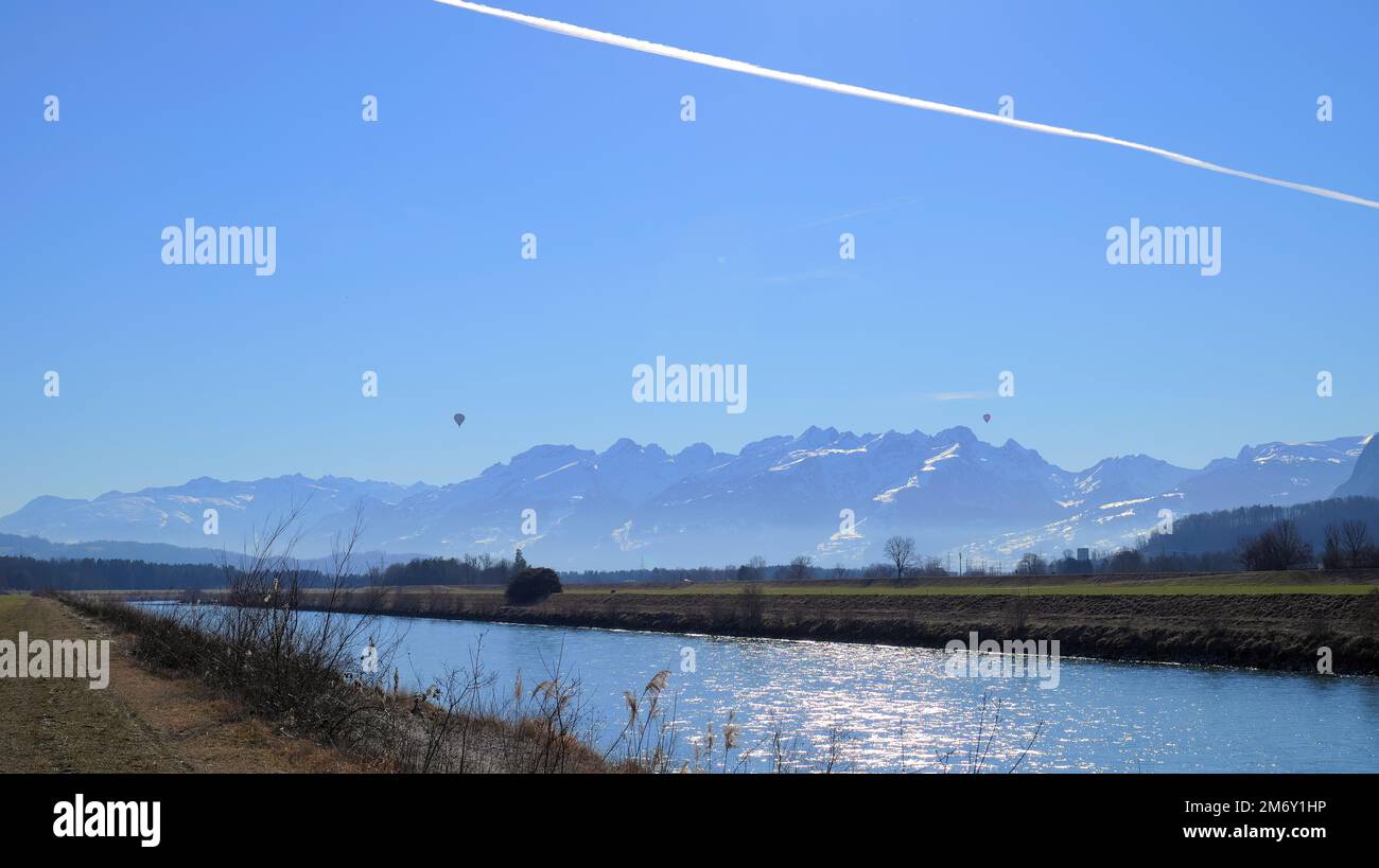 Il fiume Reno tra l'Austria e la Svizzera in inverno con due mongolfiere e contraddii da un aereo aereo nel cielo Foto Stock
