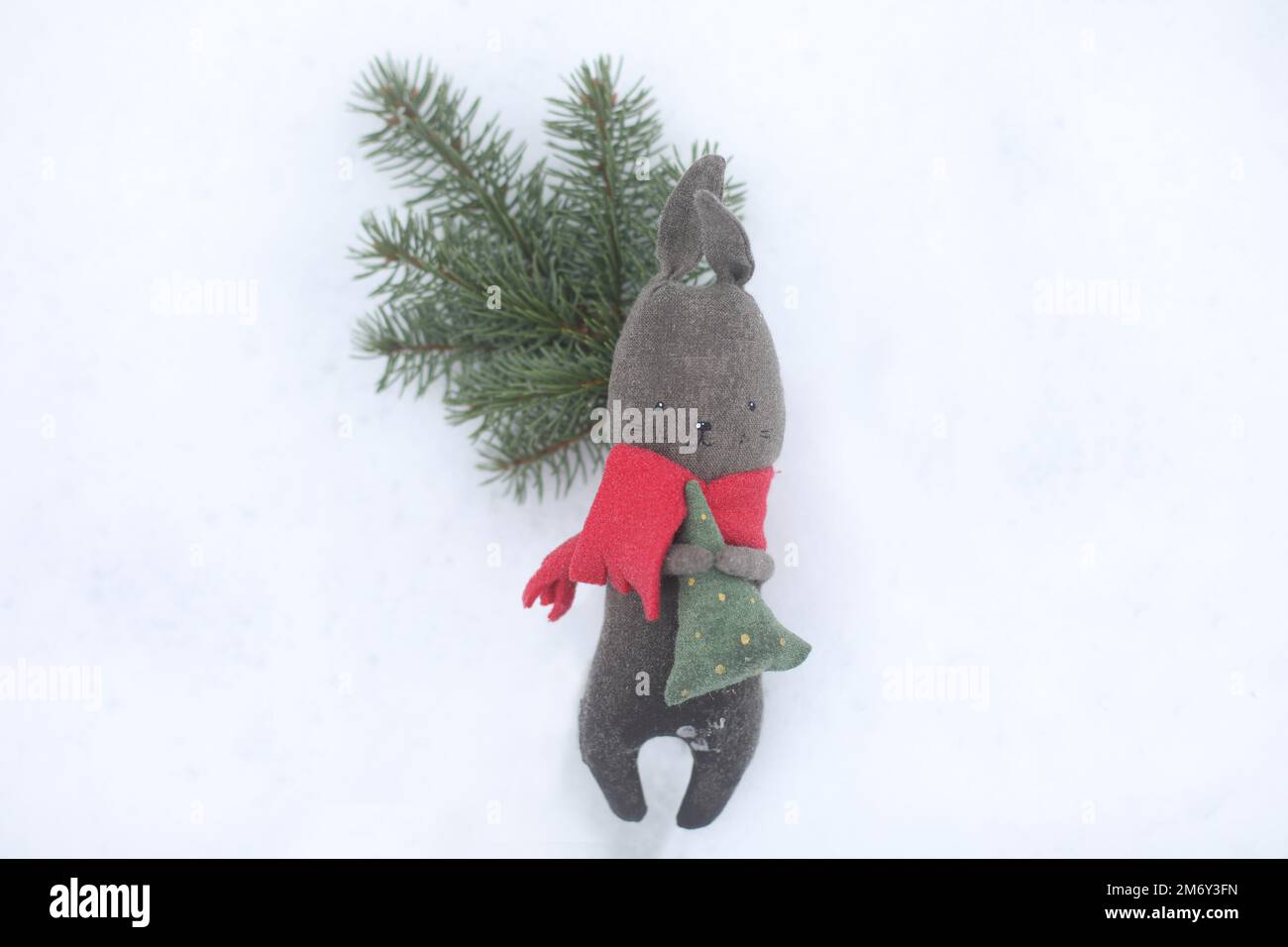 Coniglio giocattolo nero come simbolo 2023 su fondo di neve bianco. Natale e felice anno nuovo concetto. Coniglio cinese 2023 Foto Stock