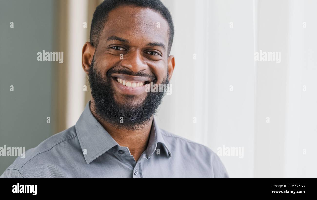 Headshot positivo adulto portatore afro americano maschio azienda manager capo capo capo CEO uomo d'affari uomo soddisfatto sorridente in ufficio cercando Foto Stock