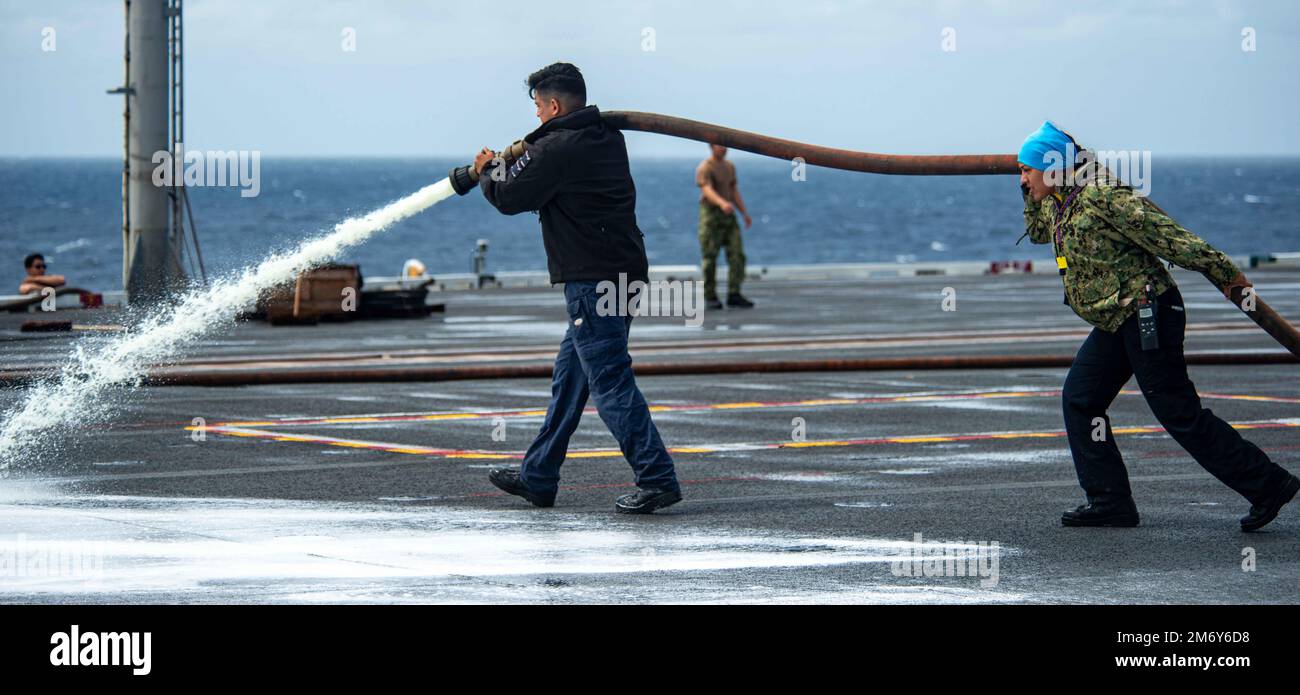 220510-N-DW158-2032 OCEANO PACIFICO (10 maggio 2022) Aviazione Boatswain’s Mate (Handling) 3rd Classe Pete Torres, di fronte, da San Antonio, e Aviazione Boatswain’s Mate (Handling) 2nd Classe Nicole pena, da Las Vegas, spruzzare sapone ponte di volo sul ponte di volo degli Stati Uniti L’unica portaerei della Marina schierata a termine USS Ronald Reagan (CVN 76) durante un lavaggio di linea del ponte aereo. I marinai di Ronald Reagan strofinano il ponte di volo per sbarazzarsi di qualsiasi accumulo in eccesso che si accumula dalle operazioni di volo giornaliere. Ronald Reagan, il fiore all'occhiello del Carrier Strike Group 5, fornisce una forza pronta per il combattimento che protetola Foto Stock