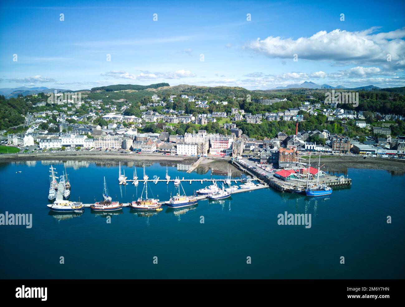 Vista aerea del drone di Oban dalla baia di Oban. Con vista sui pontoni di Oban, sul centro della città, sul North Pier e sull'Oban Esplanade, sulla McCaigs Tower e su ben Cruachan Foto Stock