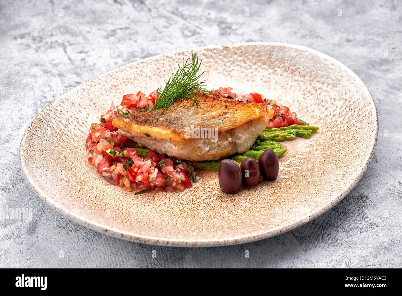 Un pezzo di zander fritto con verdure su un piatto Foto Stock