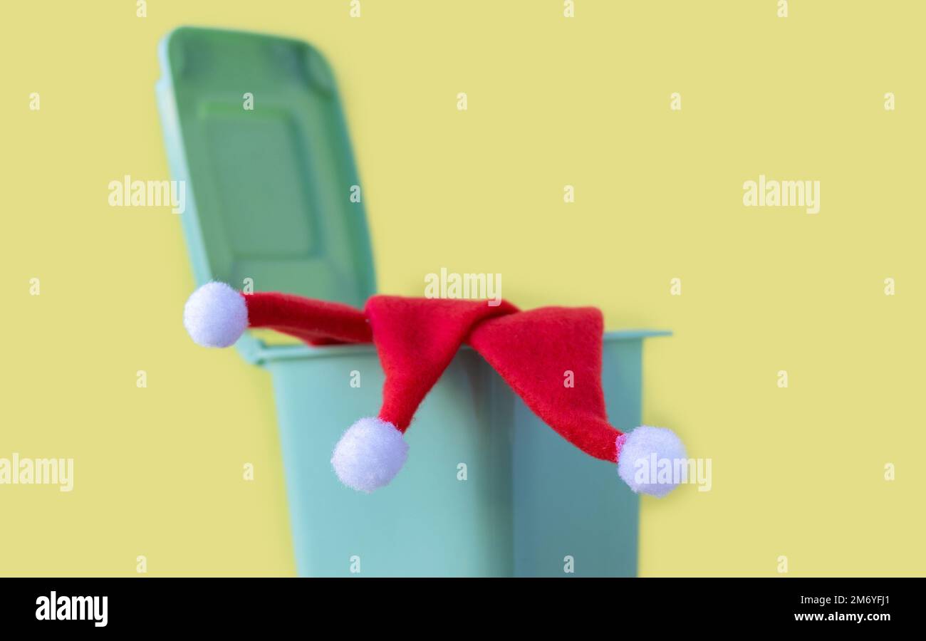 colore rosso piccolo cappello lanta berretto buttare via caduto in mini cestino spazzatura può spazzatura waste.christmas vacanza è finita o contro celebration.babbo natale Foto Stock