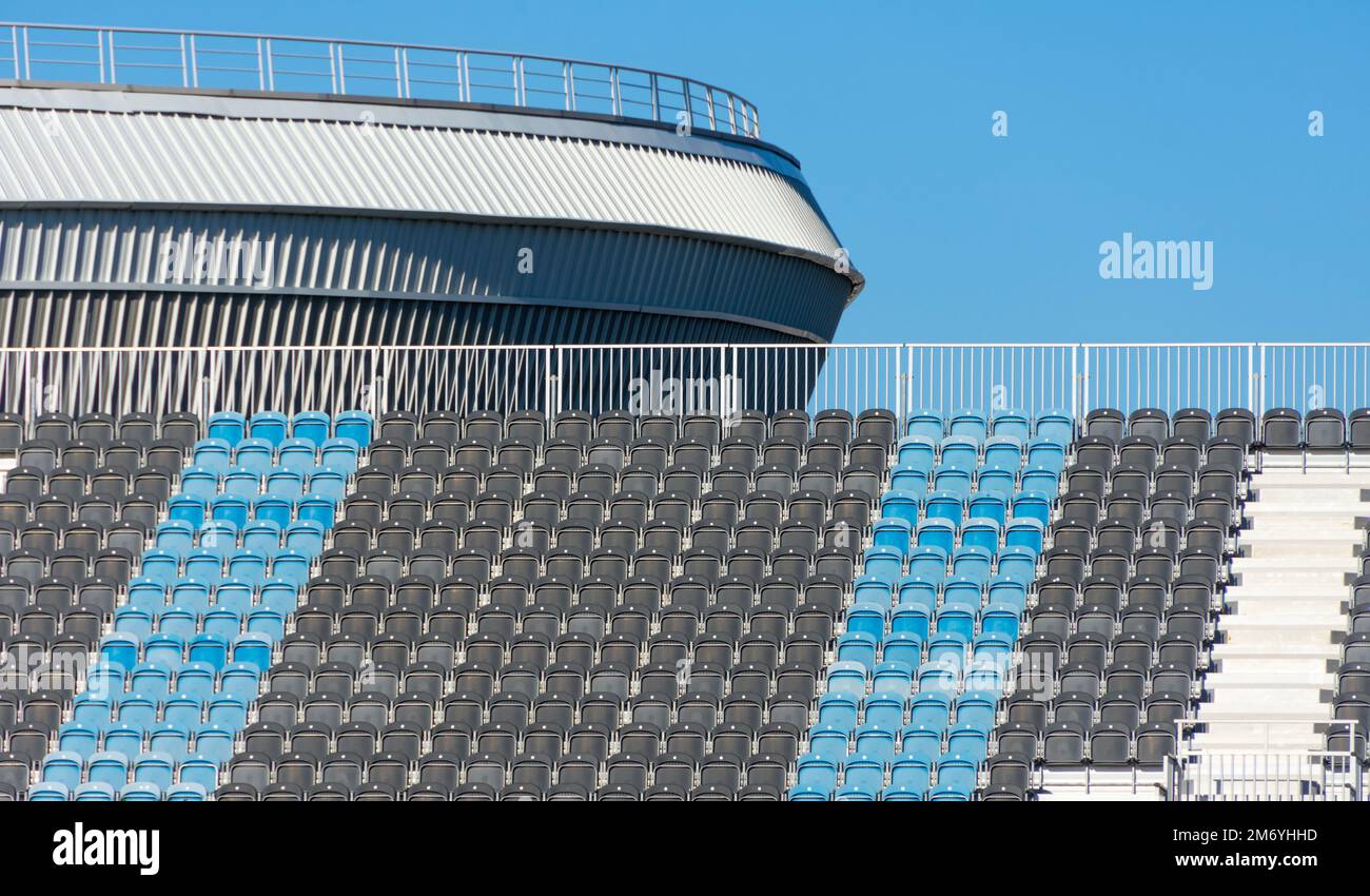 Posti vuoti neri e blu in fila allo stadio sportivo Foto Stock