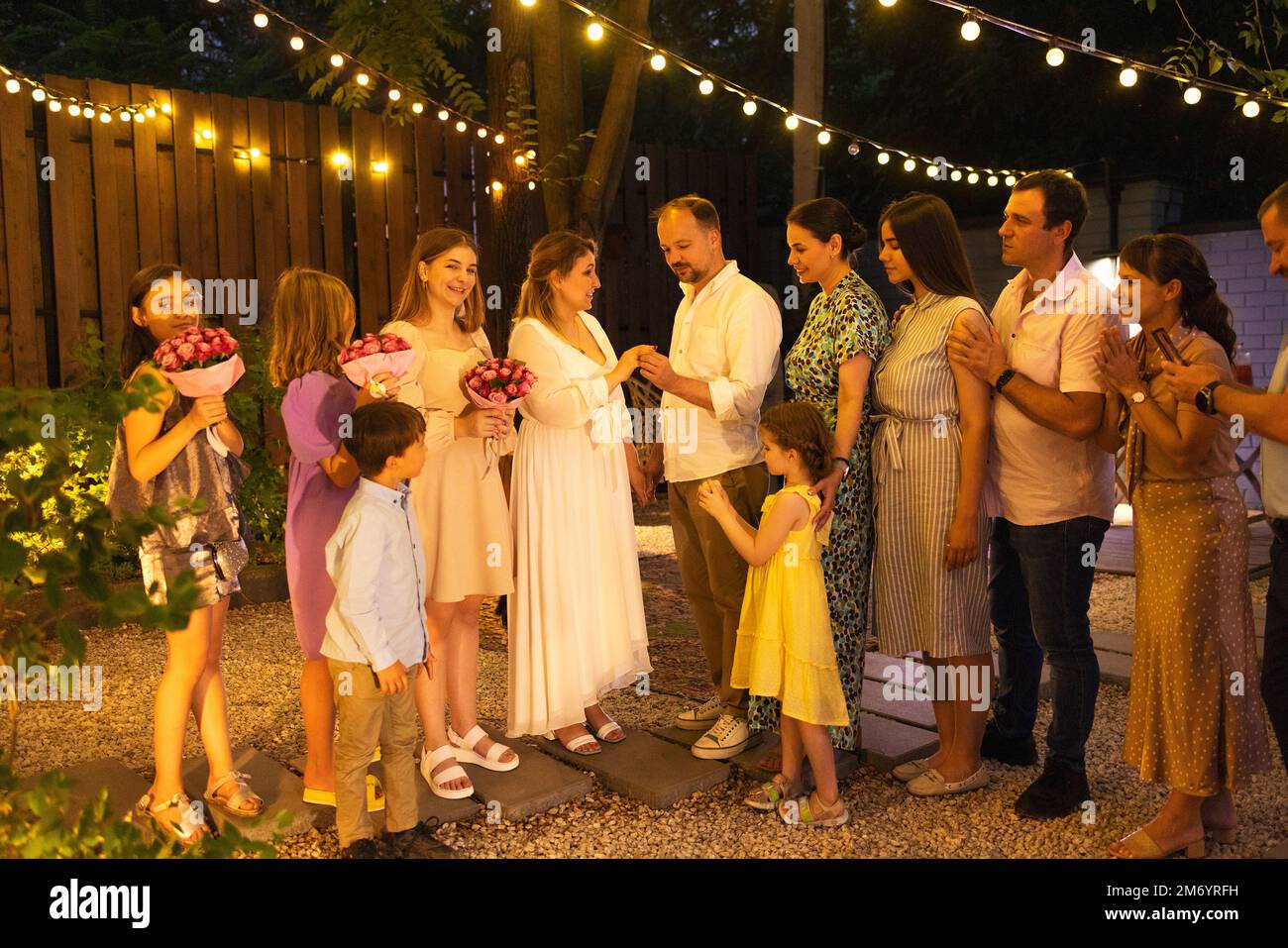 Cerimonia di matrimonio aperta. Sposa, sposo, uomo migliore, le bridesmaids intorno. Celebrazione del matrimonio all'aperto. Bouquet di fiori, anelli, voti. Amici felici. Celebrat Foto Stock