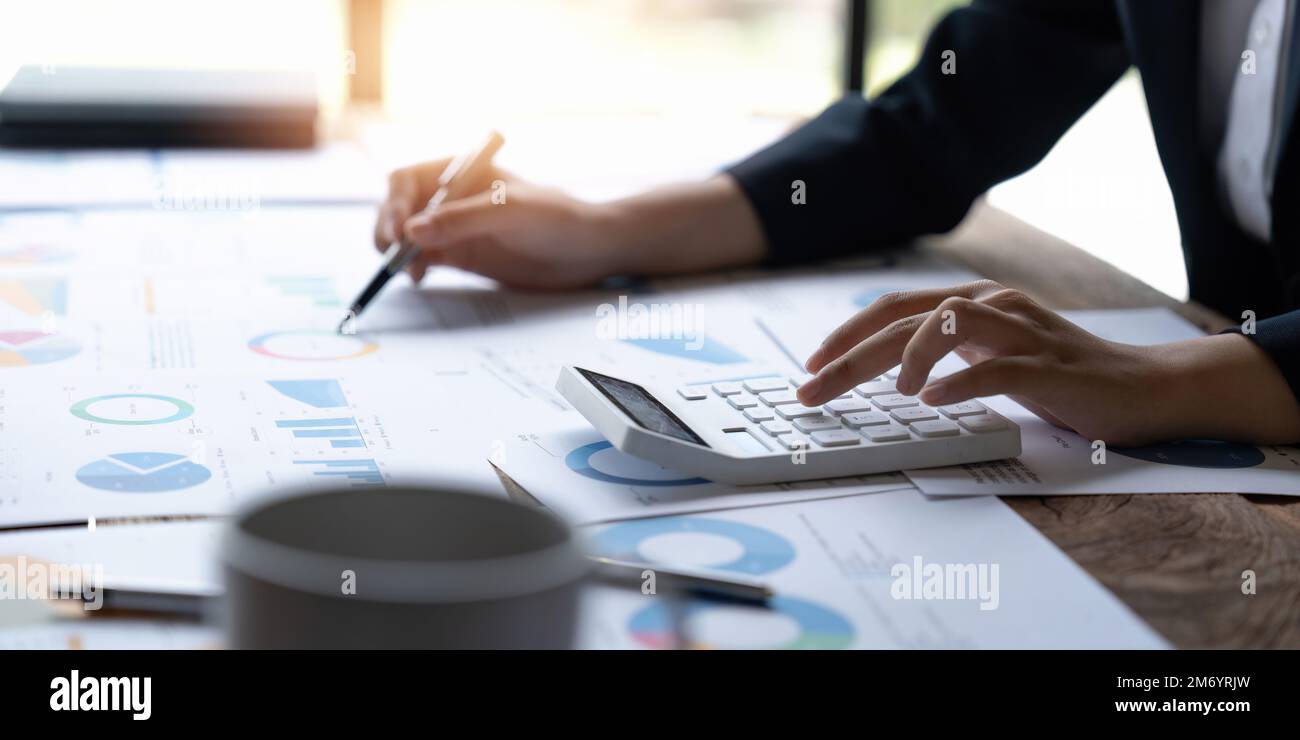 Donna contabile che lavora alla calcolatrice per calcolare la finanza dei dati aziendali. concetto fiscale, contabile, finanziario Foto Stock