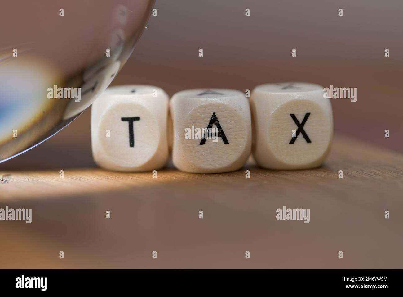 Una sfera di cristallo che brilla una luce vicino alle lettere del blocco che ortografano verso l'esterno LA TASSA, il futuro della tassa Foto Stock