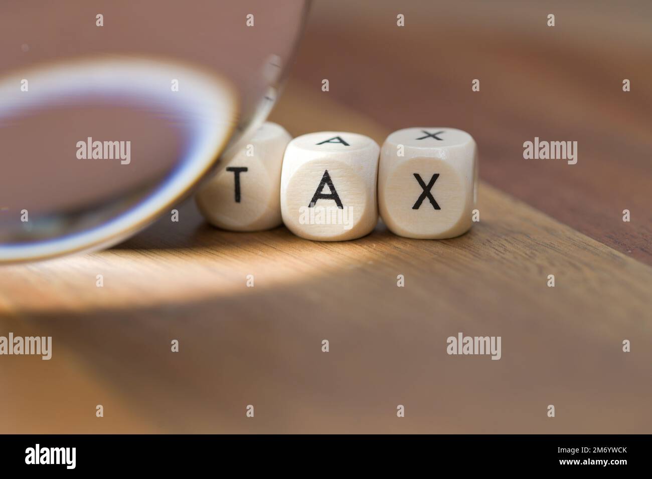 Una sfera di cristallo che brilla una luce vicino alle lettere del blocco che ortografano verso l'esterno LA TASSA, il futuro della tassa Foto Stock