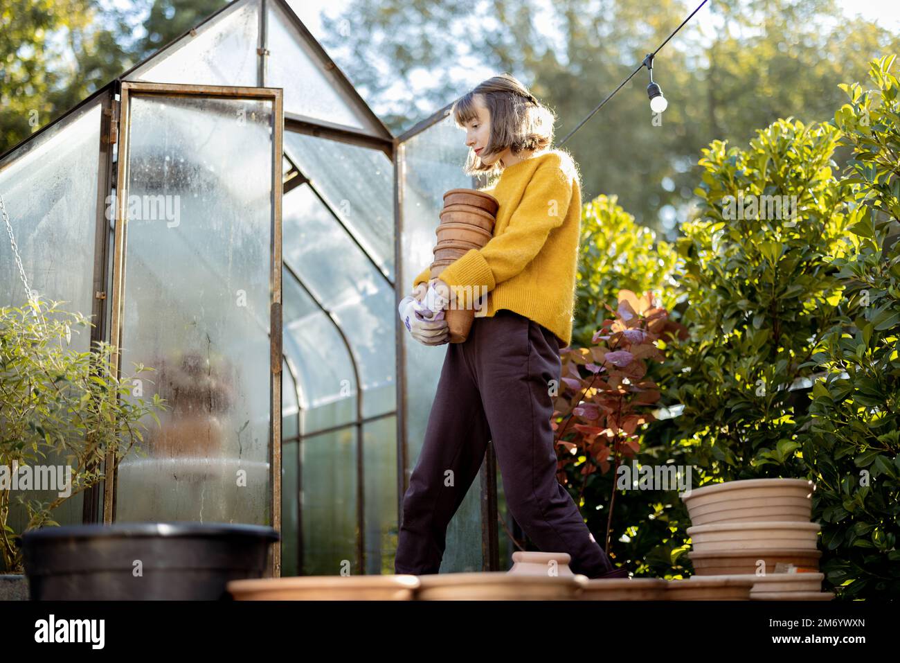 Donna con brocche in giardino Foto Stock