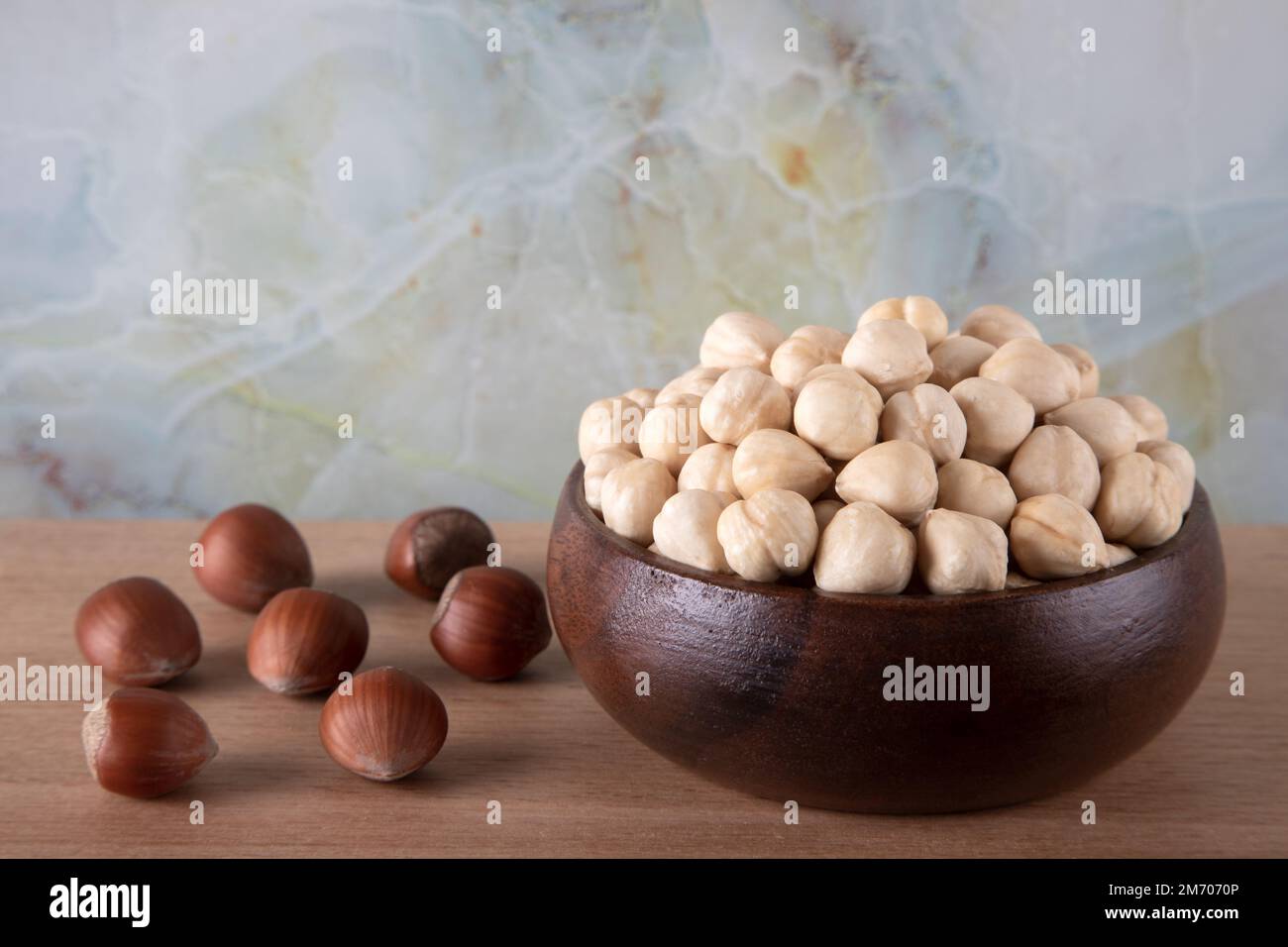 Gruppo di nocciole pelate e sgusciate su fondo di legno Foto Stock