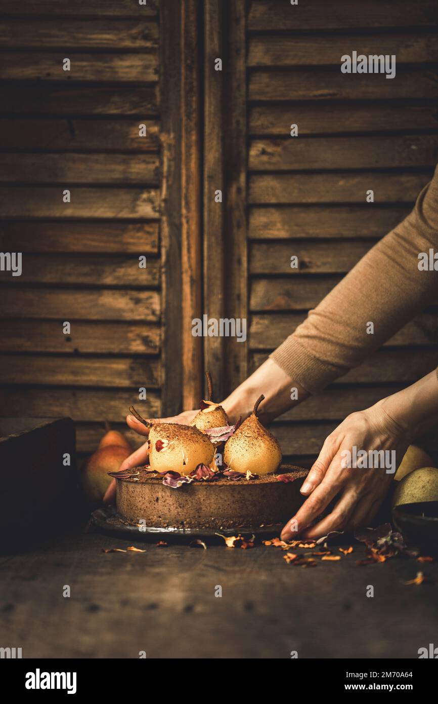Torta al cioccolato con pere tenute in mano alle donne Foto Stock