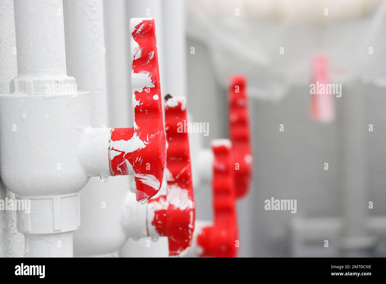 Valvola a sfera utilizzata per controllare il flusso d'acqua su un tubo in PVC che funge da gateway con il primo piano della maniglia Foto Stock