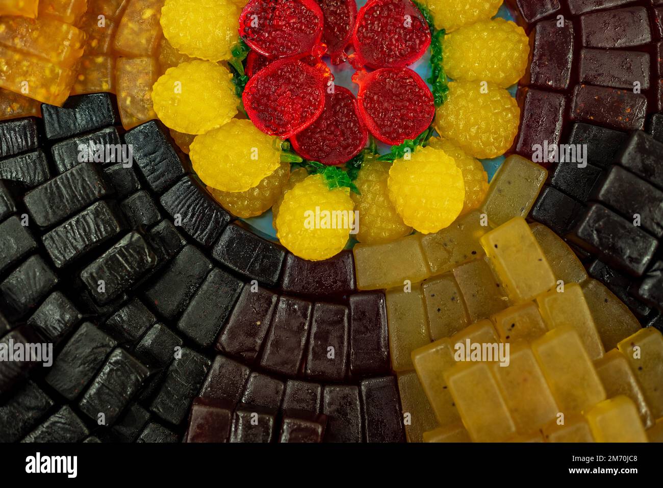 molte caramelle di marmellata colorate disposte su una superficie piana; dessert per le vacanze; dolci regali per i bambini; consistenza e sfondo con piccole caramelle Foto Stock