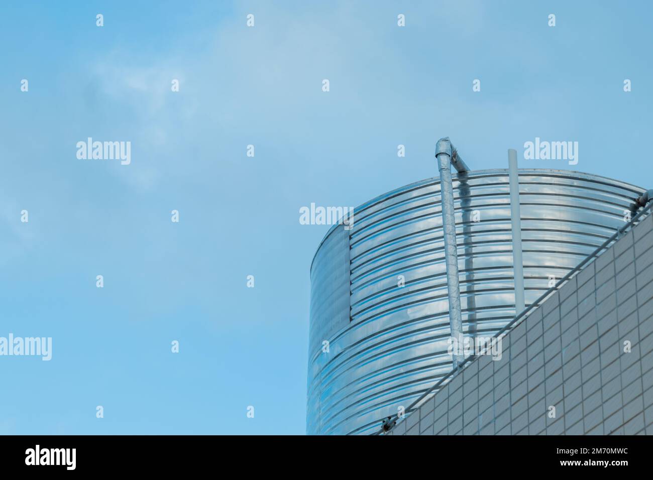 Un basso angolo di un moderno edificio rotondo contro il cielo chiaro e illuminato dal sole Foto Stock