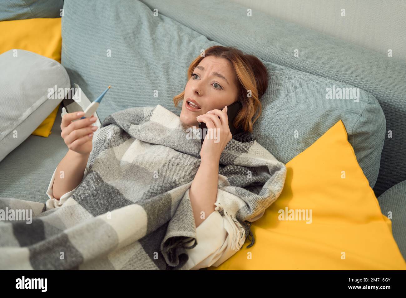 Donna malata che parla sullo smartphone in camera da letto Foto Stock