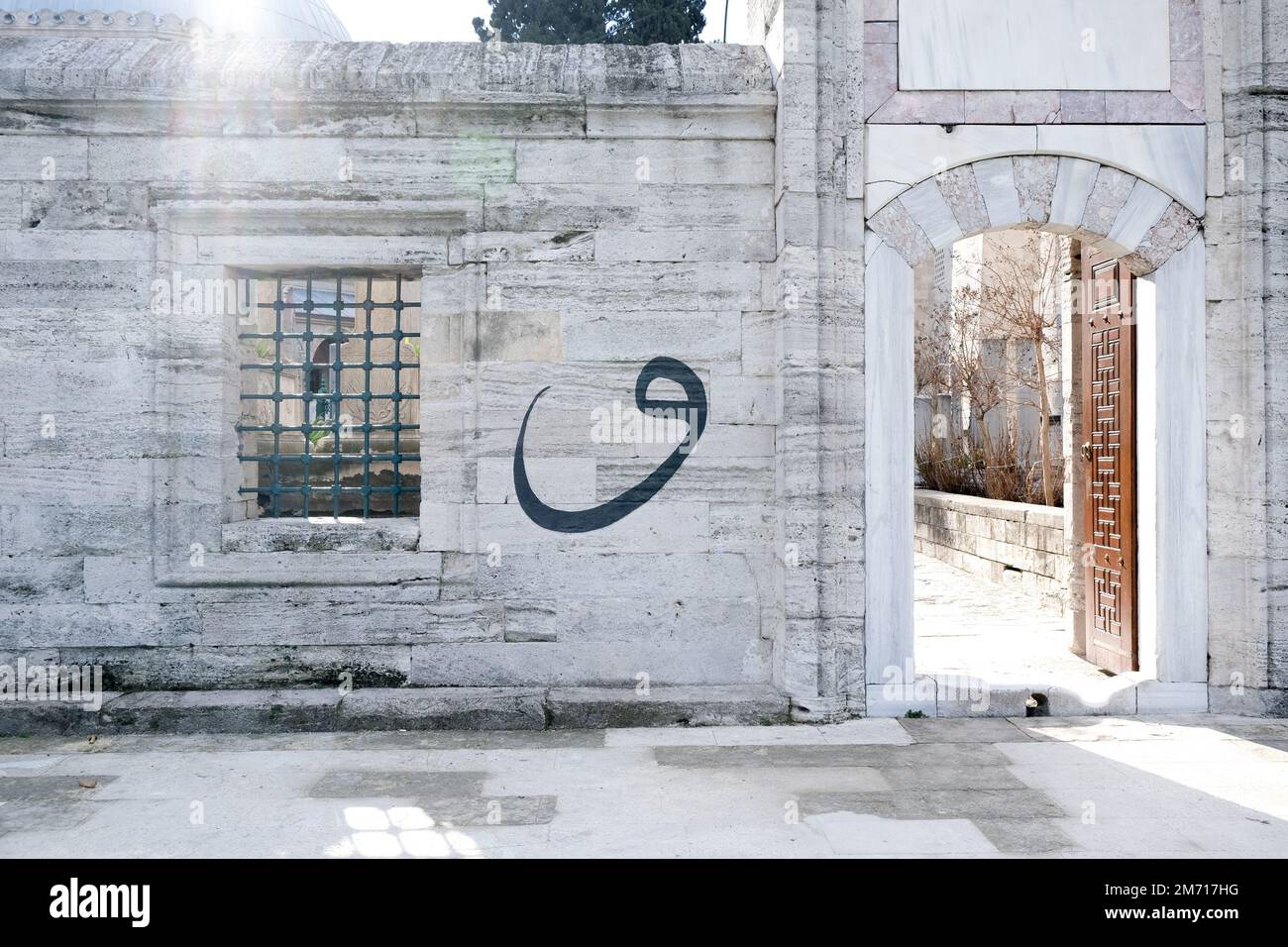 La lettera araba Vav è scritta sulla parete. Sfondo della lettera araba. Concetto Ramadan. Messa a fuoco selettiva. Foto Stock