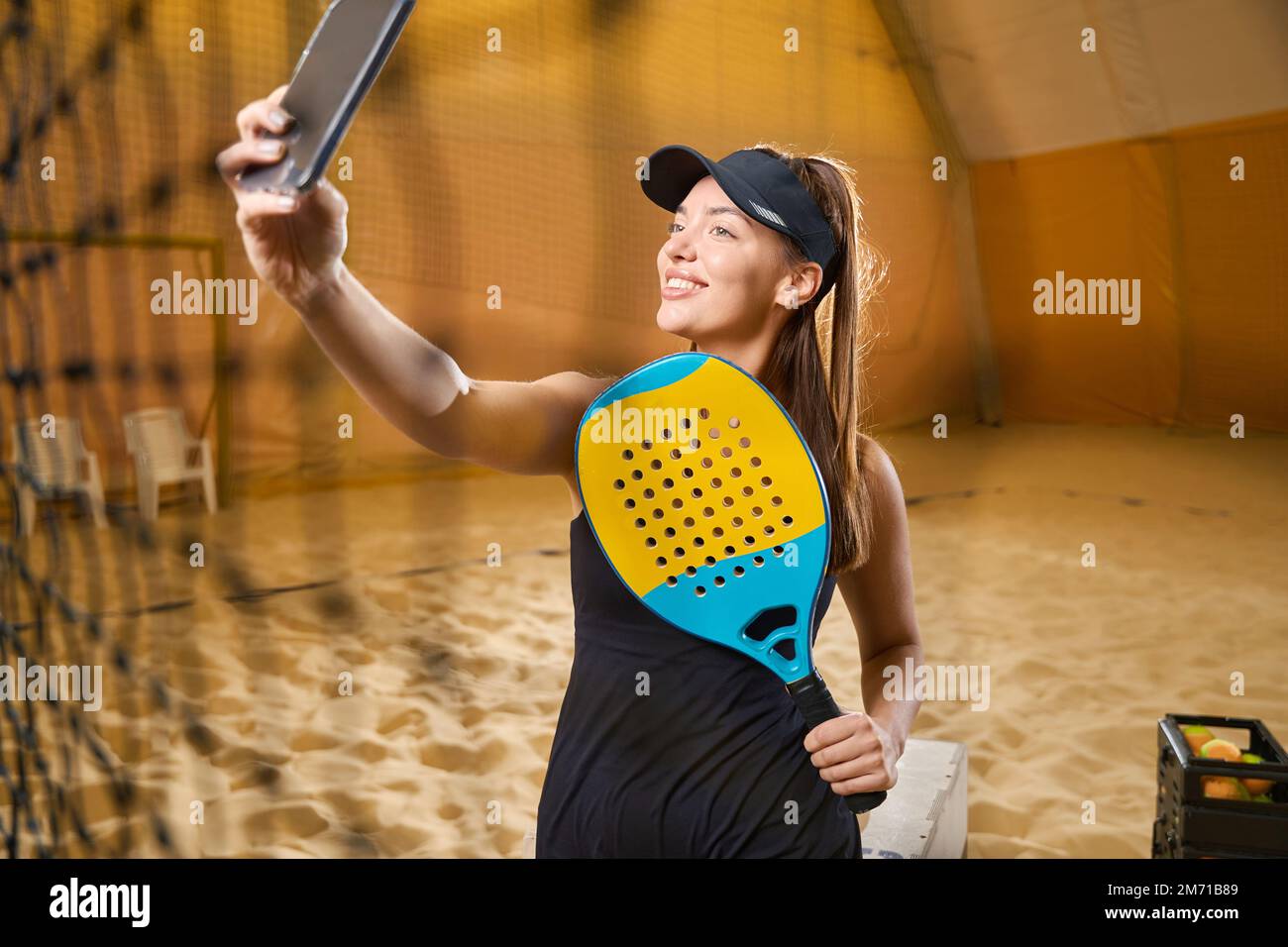 Donna prende selfie in uniforme sportiva e racchetta in mano Foto Stock