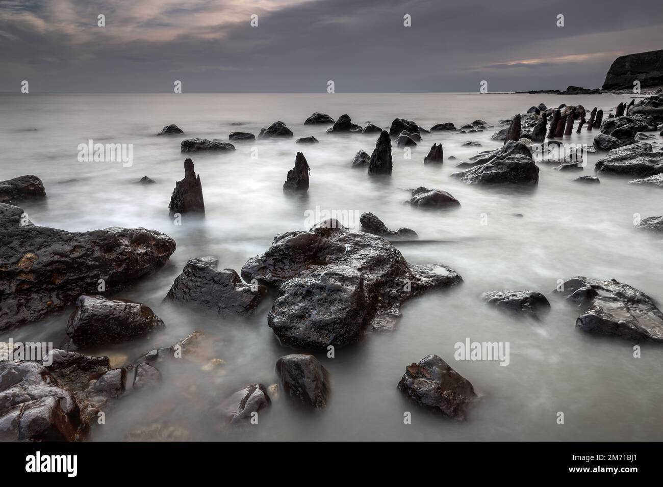 Tempo usura Groynes e vecchi detriti industriali sono lentamente riciclati dalla natura sulla spiaggia chimica, Durham Heritage Coast, Seaham, County Durham, U. Foto Stock