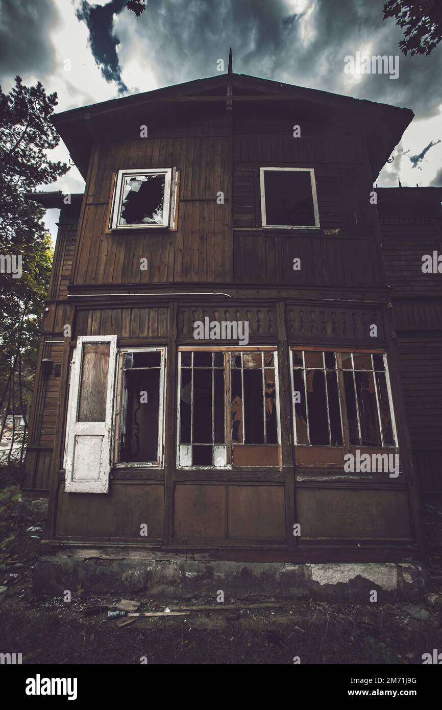Vecchia casa spaventosa contro il cielo nuvoloso scuro Moody cielo Foto Stock