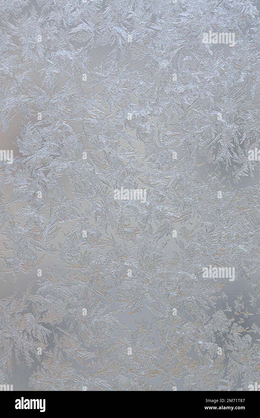 Gocce di acqua di vapore condensata congelate sul vetro trasparente del finestrino. Sfondo blu pulito. Condensazione dell'umidità a temperature estreme. Foto Stock