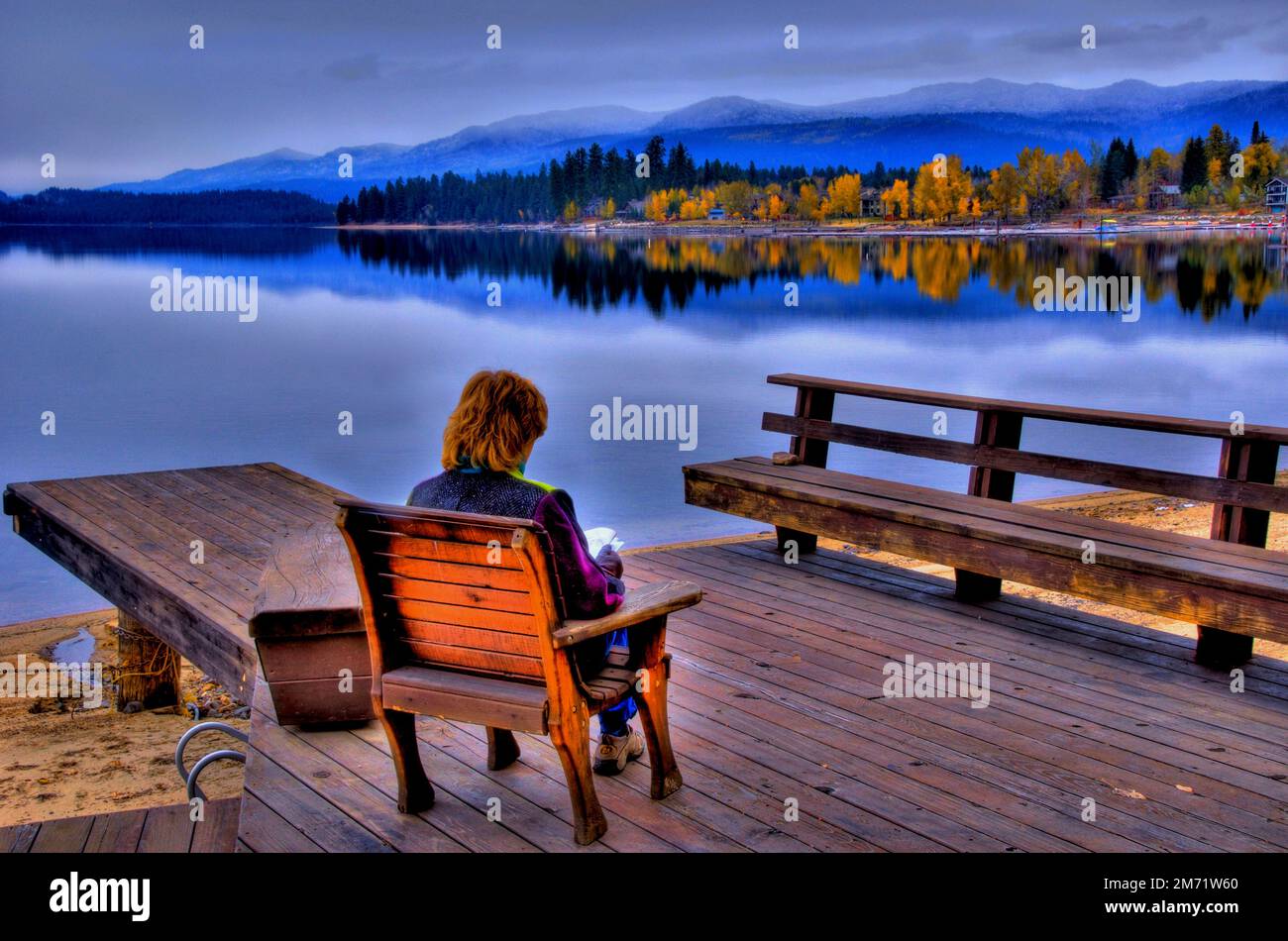Stati Uniti d'America, Idaho, McCall, Lago Payette, donna di lettura su un dock Foto Stock