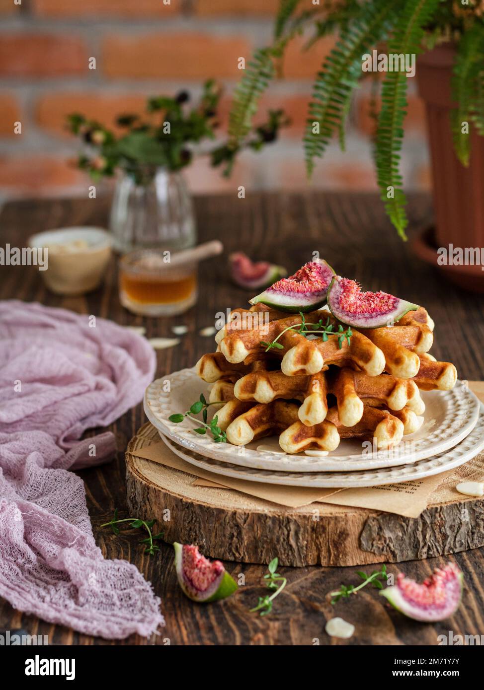 Impila di cialde con fichi, timo e miele su un asse rustico di legno. Foto Stock