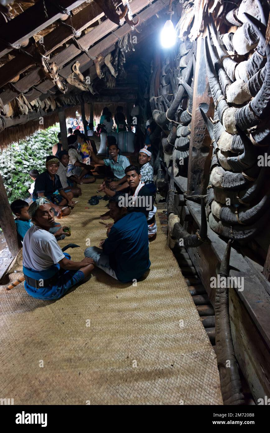 Gli uomini si siedono in un circolo bevendo durante il Wulla Poddu, un tradizionale mese santo a Sumba. Foto Stock
