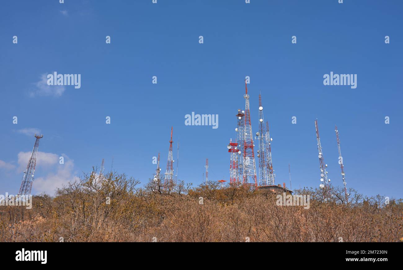 torri di comunicazione sulla cima di una montagna nel mezzo della foresta desertica, cielo blu nei giorni estivi, nessuna gente, rocce e palme Foto Stock