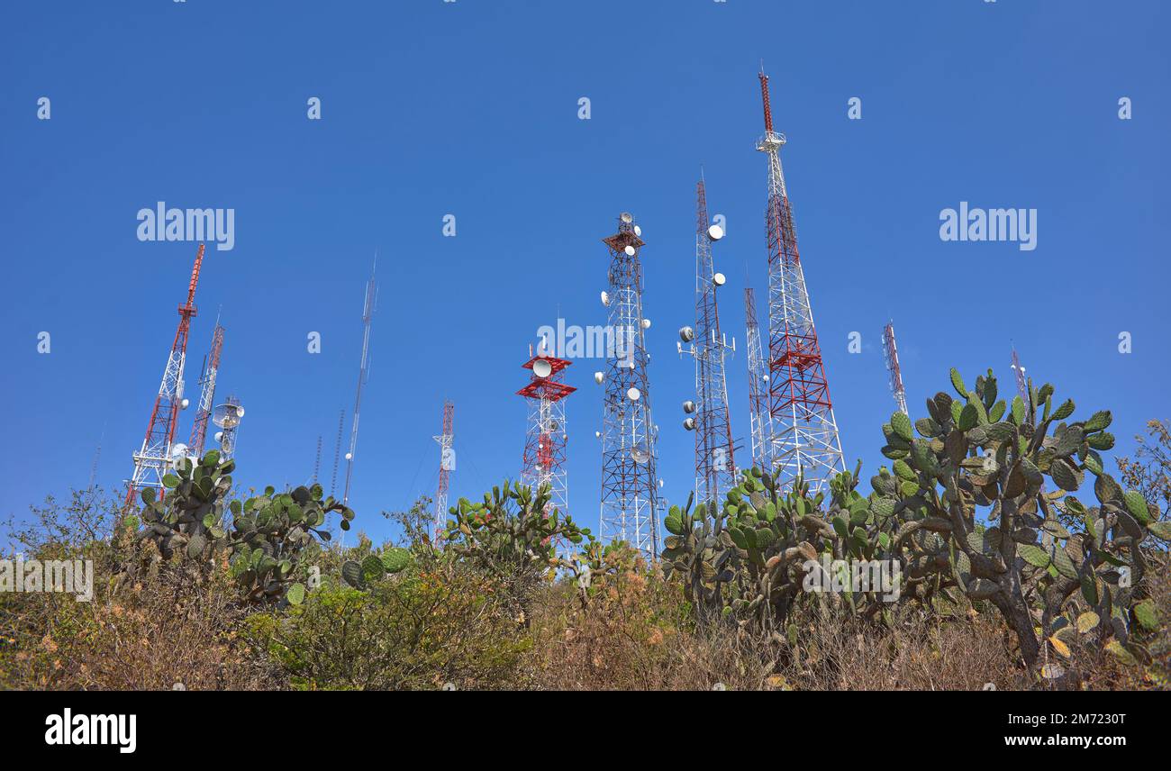 torri di comunicazione sulla cima di una montagna nel mezzo della foresta desertica, cielo blu nei giorni estivi, nessuna gente, rocce e palme Foto Stock