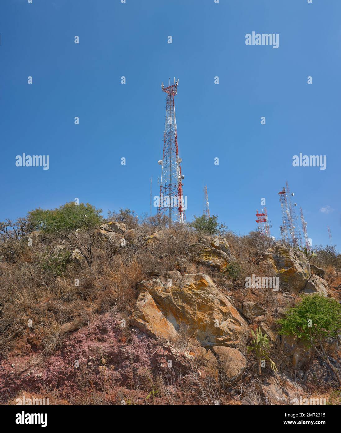 torri di comunicazione sulla cima di una montagna nel mezzo della foresta desertica, cielo blu nei giorni estivi, nessuna gente, rocce e palme Foto Stock