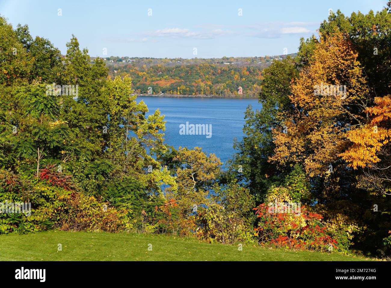 Una vista sull'acqua a distanza con lo sfondo del fogliame autunnale vicino al lago Cayuga, New York, U.S.A Foto Stock