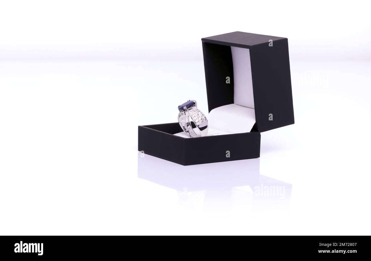 Anello in platino con zaffiro blu e diamante in scatola gioiello blu scuro. Collezione di gemme naturali accessori. Foto da studio Foto Stock