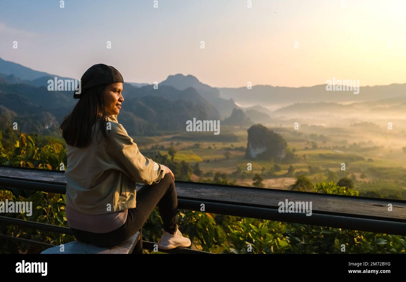 Donne che guardano l'alba con nebbia e nebbia ai monti Phu Langka nel nord della Thailandia, Vista montagna del Parco Nazionale Phu Langka nella provincia di Phayao Foto Stock