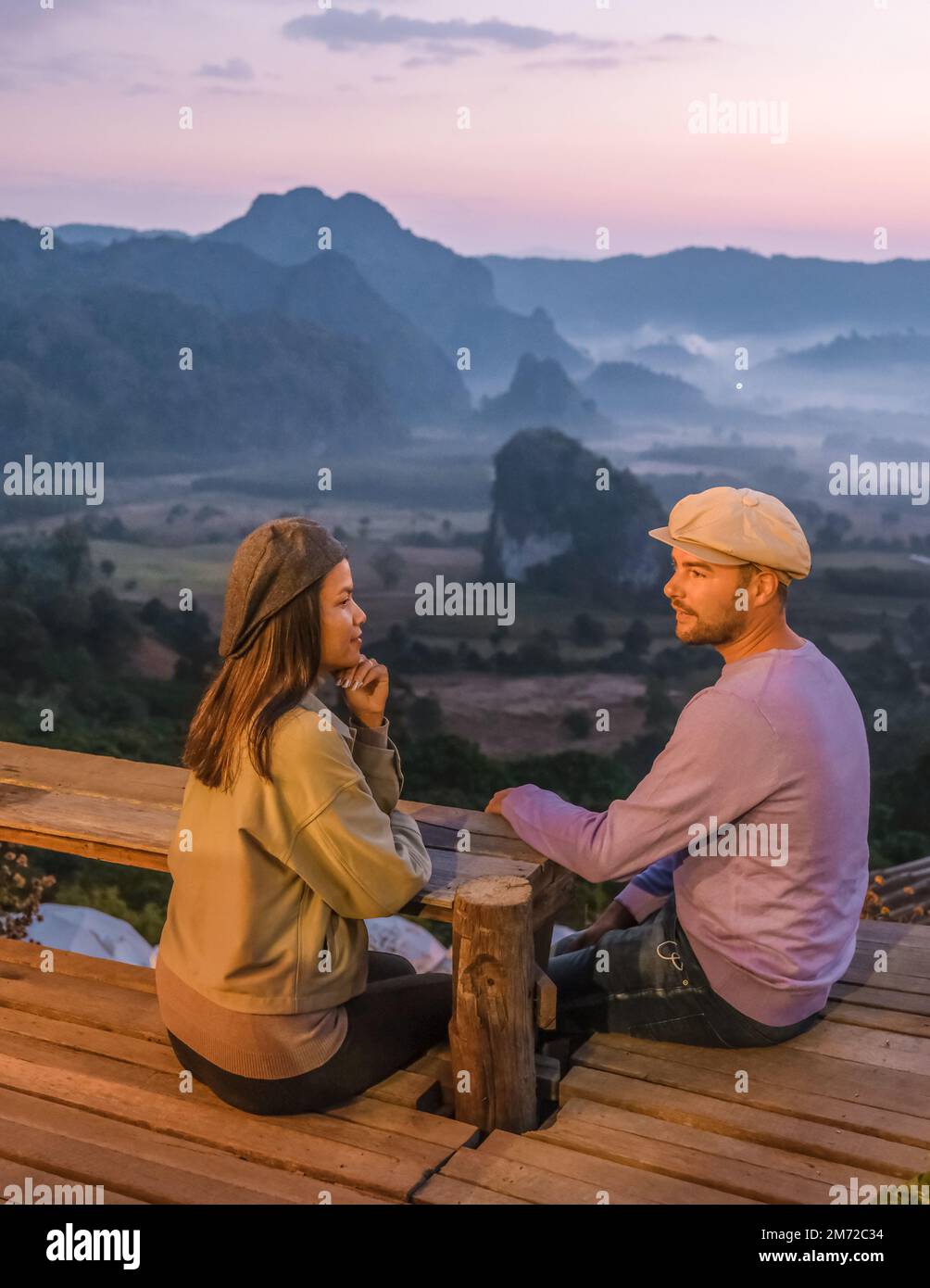 Un paio di uomini e donne che osservano l'alba con nebbia e nebbia sulle montagne di Phu Langka nel nord della Thailandia, vista sulle montagne del Parco Nazionale di Phu Langka nella provincia di Phayao Foto Stock