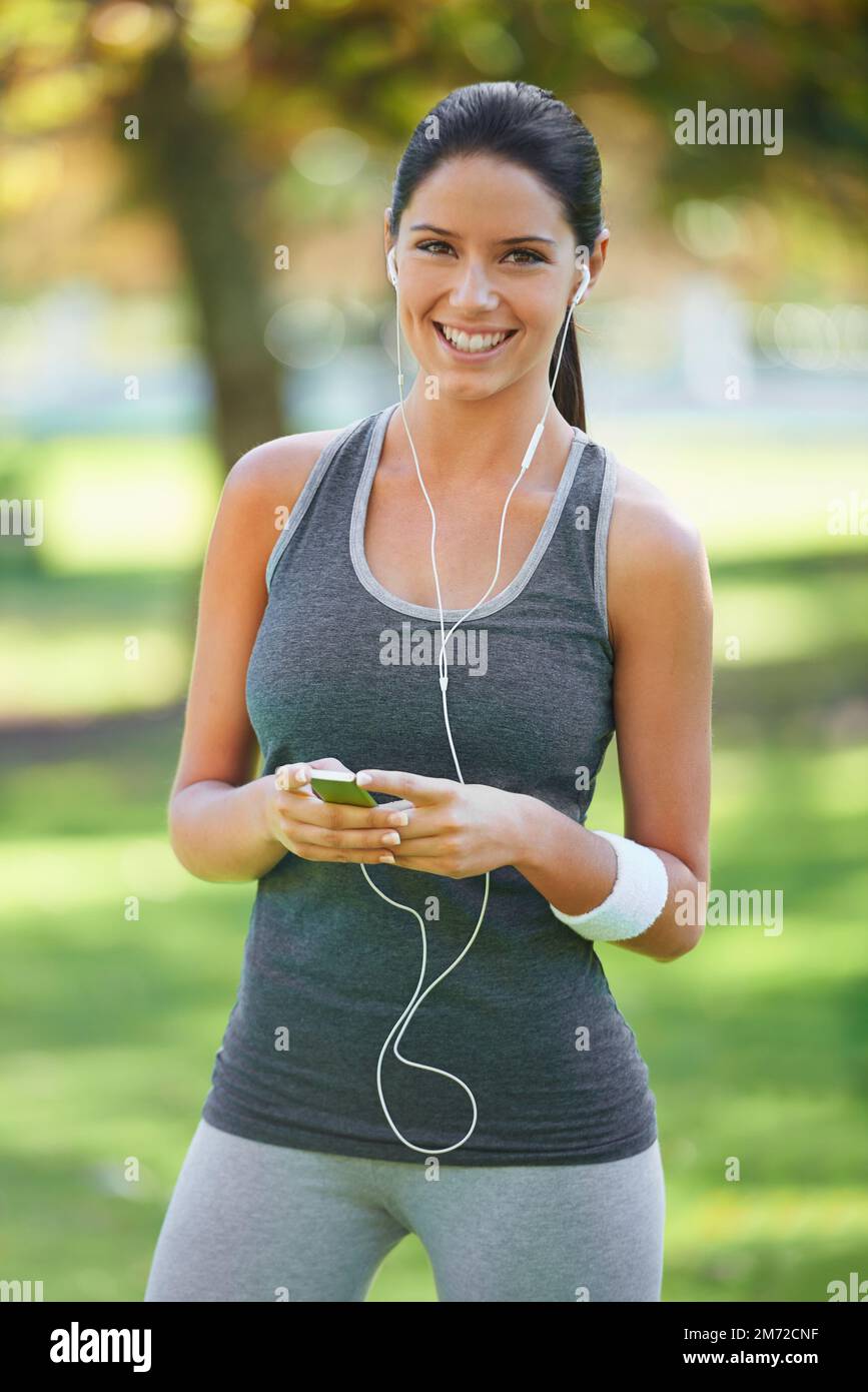 Questa playlist è perfetta per il mio allenamento. un giovane runner che indossa le cuffie. Foto Stock