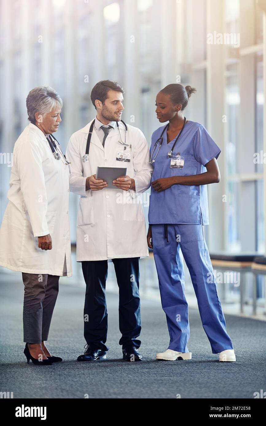 La tecnologia moderna svolge un ruolo importante nelle loro decisioni. un team medico che utilizza un tablet digitale insieme. Foto Stock