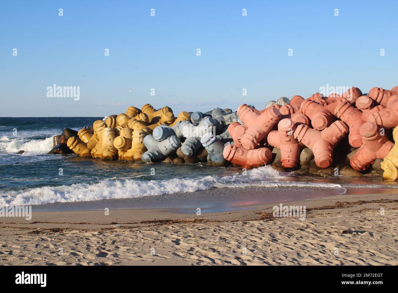 Pietre colorate del molo sulla spiaggia Foto Stock