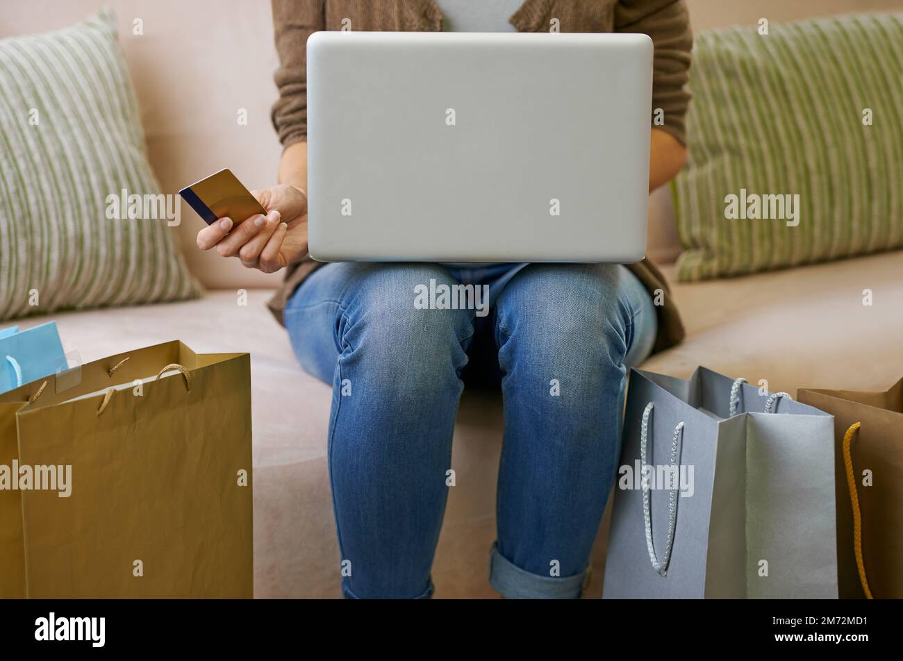 Fare acquisti online è molto comodo. una donna che fa un po' di shopping online a casa con il suo notebook. Foto Stock